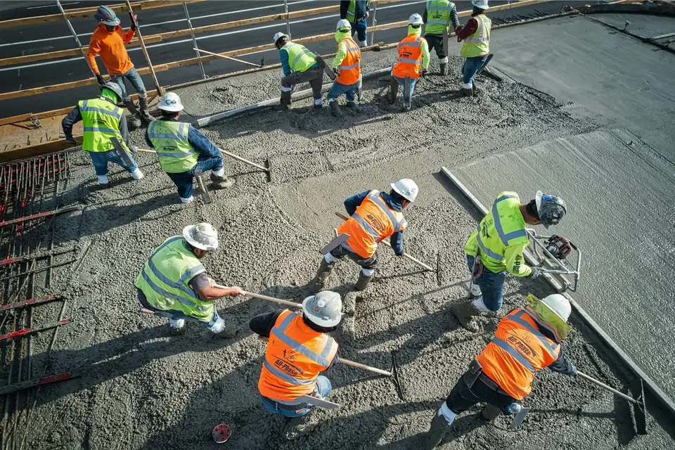 Cuadrilla colando banquetas de concreto